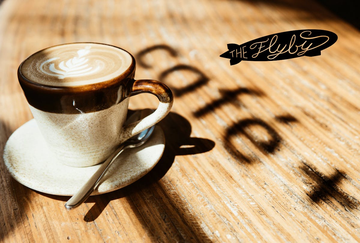 a close up of a coffee cup sitting on top of a wooden table